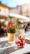 © dinatychynska - Stylish mason jar mocktail with red berries, rosemary and lemon on sunny outdoor cafe terrace table, capturing refreshing summer drink concept perfect for menu or lifestyle content.
