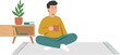 © Irene - A man sits cross-legged on a rug in a room with a plant and furniture
