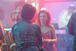 © DC Studio - Women talking while relaxing at discotheque party in nightclub. Girlfriends having conversation and enjoying nightlife leisure while clubbing and attending disco gathering in club