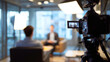 © Fox - Professional video interview setup in modern office environment with camera recording two business people. Bright studio lights illuminate the scene, creating a dynamic and engaging atmosphere