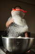 © Taras Grebinets - Person Sifting Flour Over Metal Bowl While Baking in Kitchen, Flour Dust in Motion