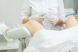 © Maria - Gynecologist with forceps examining female patient on gynecological chair holding forceps