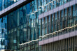 © yaqui_villegas - Blue abstract pattern and reflection ripple across glass windows on modern architecture building facade creating cinematic urban surface texture