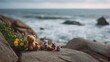 © Bussakon - A collection of miniature toys rests on wet textured rocks overlooking the vast ocean at the seashore
