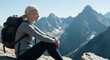 © soleh - Woman hiker sits atop a mountain peak, gazing at vast mountain range