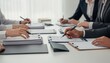 © Justlight - Medium shot of healthcare office staff collaborating over workers compensation claims clear focus on paperwork and hands with an outoffocus background creating depth.