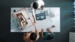 © InfiniteFlow - Top down view of civil architect looking at project plan while present to investor at meeting table. Aerial view of skilled designer explain about construction to business people listen. Alimentation.