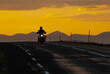 © PálmiG - Motorcyclist riding on open road at sunset with silhouette against golden sky in Iceland landscape