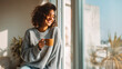 © Yaroslav Stepannikov - Woman drinking coffee and smiling at window, morning lifestyle scene, bright soft light, large copy space
