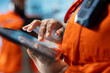 © DC Studio - Close up of drilling rig specialist using tablet to evaluate spill prevention systems to reduce ocean contamination. Environmental protection professional monitoring carbon footprint with device