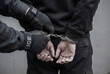 © Rolands - ICE federal agents arresting citizen and applying handcuffs to suspect on city street for news report
