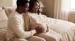 © Morrina - Mother's Day pregnant woman and husband on bed sharing intimate moment expressing love tenderness for lifestyle magazine editorial content