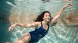 © Mikhail - Woman swimming underwater in pool. Young female athlete enjoying aquatic activity. Healthy lifestyle, recreation and summer leisure concept. Graceful moving in clear blue water.