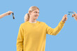 © Pixel-Shot - Young man and female hands holding car key with driving license on blue background
