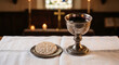 © slowlife kim - Holy communion bread and silver chalice of wine on white linen.