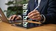 © jsni - A businessman in a suit checks a digital checklist on a tablet