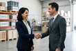© Meow Creations - Business professionals shaking hands inside a large warehouse logistics center