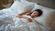 © bephoto - 上質なベッドで日本人女性が静かに眠るホテル滞在の夜景写真