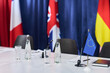 © pressmaster - Wide shot of conference table displaying European Union flag, microphones, documents, water glasses before diplomatic meeting. Suitable for government policy, international summit