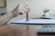 © khunkornStudio - Notary public hand using wooden rubber stamp legal contract paper desk official document authorization corporate partnership agreement validation law firm administration concept.