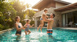 © Prdn - Authentic luxury lifestyle photo of happy modern family with two children playing together in a bright turquoise backyard swimming pool on sunny summer afternoon