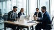 © Svitlana - Professionals at a table working on laptops during a meeting, clean workspace, concentrated expressions and business attire, modern office clarity and efficiency, ultra-realistic, no logos.