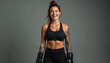 © Pete - Fit woman in black sportswear laughs hard, wearing boxing gloves. Muscular female shows confidence and strength, ready for fight. She trains actively for competition.