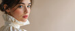 © NeuroCake - Portrait of a young woman looking over her shoulder in a cream ruffled blouse. Spring fashion concept on a beige backdrop