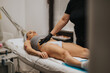 © qunica.com - A woman receives a bikini waxing treatment from a technician at a beauty center. A professional esthetician performs hair removal while the client lies on a treatment table.