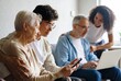 © WindJoy - Older and younger people sit together using a phone and laptop, showing patient digital support at home.