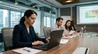 © Justlight - Conference room scene with commercial property risk assessment primary underwriter concentrating on laptop data other members and charts subtly out of focus.