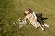© Anna - loving couple hugs and kisses while lying on grass on sunny day. A sensual tender shot of groom and bride in simple embroidered dress. moment of intimacy, an important date, a happy relationship