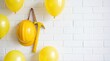 © 5 Grace Media - Yellow hard hat and pickaxe hanging on a white brick wall surrounded by festive balloons.