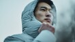© Bargais - Asian model in a thick down jacket with a hood.