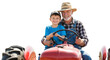 © Marin Studio - A smiling old man and a young boy sitting on a red tractor together.