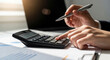 © Myimages - Business professional using calculator and laptop for budget planning, tax calculation and financial analysis, concept of accounting management and cash flow control