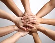 © Ahmad - Close-up of diverse hands stacked together, signifying teamwork and unity. Different skin tones are visible, showcasing solidarity