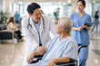 © Khemmanat - Healthcare Professionals Attending Patient: A doctor and a nurse are attending a senior patient in a hospital setting, illustrating compassionate care and medical attention.
