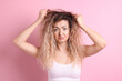 © New Africa - Unhappy woman with tangled hair on pink background