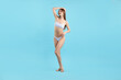 © New Africa - Beautiful woman wearing stylish swimsuit on light blue background