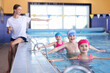 © New Africa - Coach teaching little kids to swim in pool, selective focus