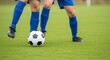 © rahul09 - Two athletic soccer players compete intensely for possession of the ball during an exciting match on a lush green grass field while wearing blue uniforms and protective gear on legs