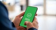 © Recon - A person holding a smartphone with a green screen displaying a payment complete message.