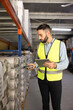 © fizkes - Worker holding digital tablet, scanning barcode with scanner in industrial warehouse. Supply management, inventory control, logistics profession, technology integration for distribution and storage