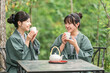 © buritora - A young Asian woman in a yukata (traditional Japanese summer kimono) drinking tea while enjoying a forest bath during her travels.