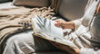 © PixelFoundry - Person reading an open book on a sofa with leaf shadows