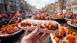 © tangmo.pa - Holding a frikandel speciaal street food at a King's Day canal celebration.
