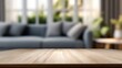 © Matthew - Wooden tabletop with blurred sofa in the background, sunlight filtering through large windows