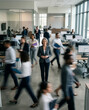 © anarda - Portrait of a confident mature businesswoman standing still in a busy modern office with motion blurred colleagues