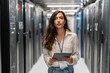 © sogap - Hispanic female server technician holding tablet in data center aisle